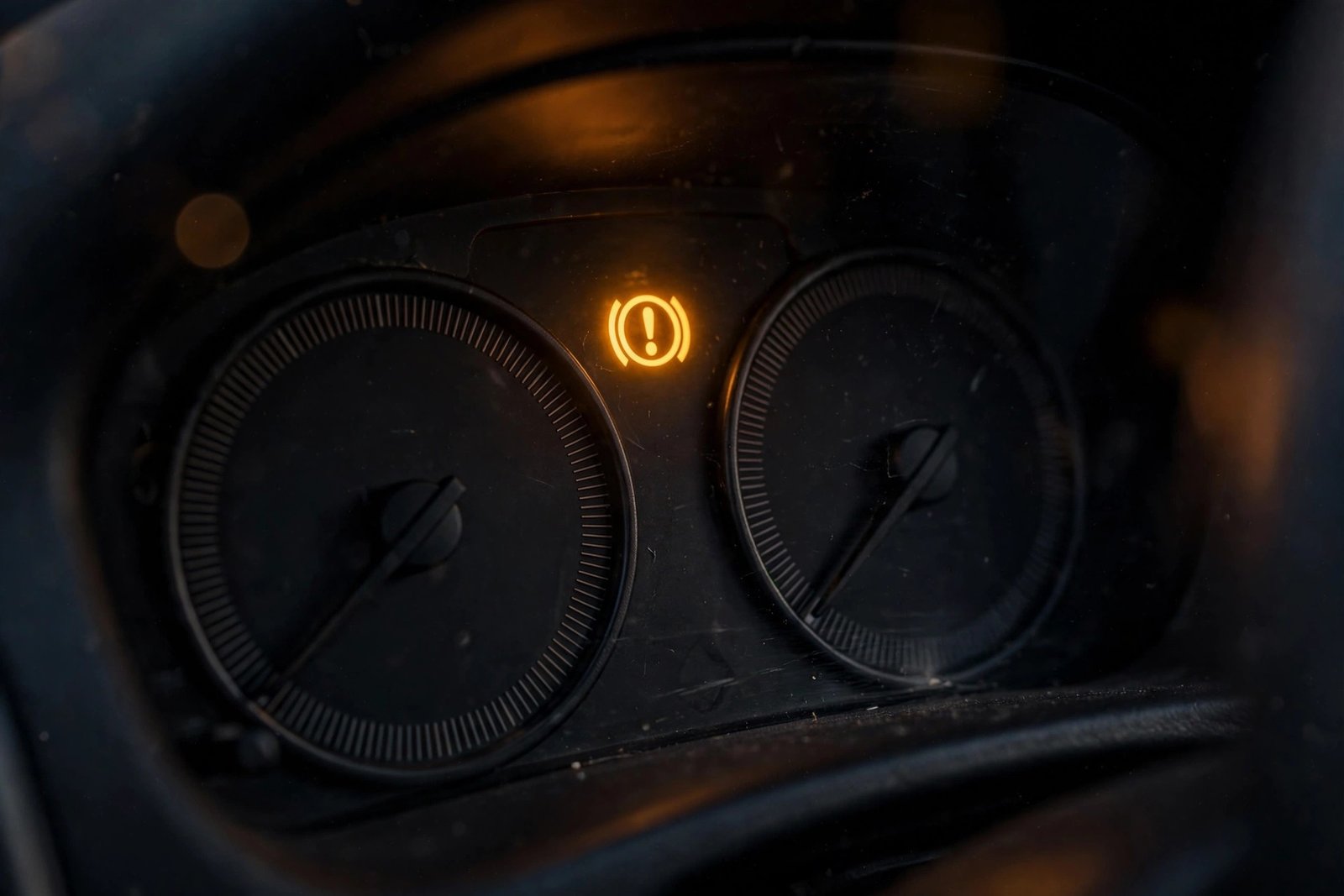 Amber ABS warning light glowing on a car dashboard while driving at night