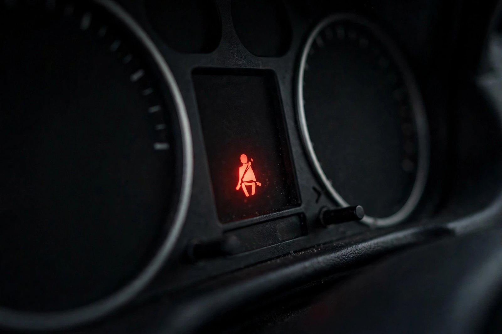 Car dashboard with red airbag SRS warning light illuminated