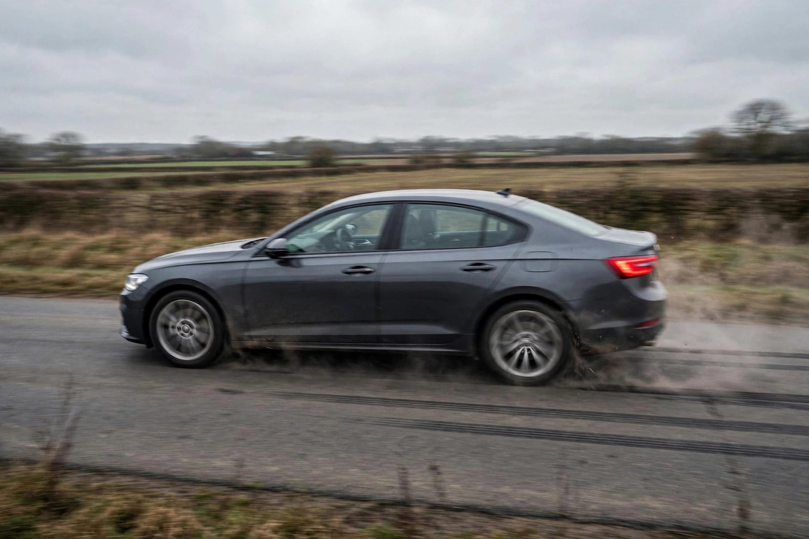 Car braking with increased stopping distance on a road, brake lights illuminated